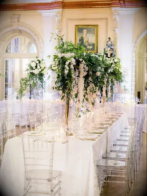 Romantic white reception decor with tall greenery centerpieces