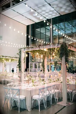 Indoor wedding reception with pergola and string lights