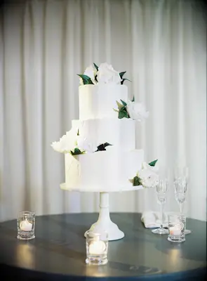 White three-tier wedding cake with white cake stand