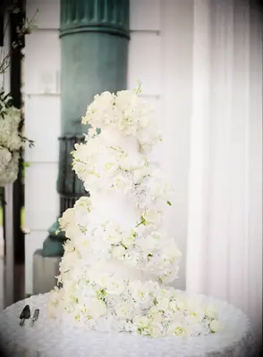 Ornate wedding cake covered in lots of fresh flowers