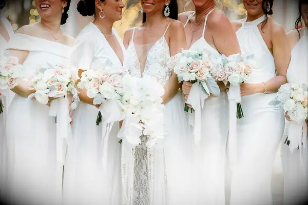 Bridal party in white dresses with white floral bouquets