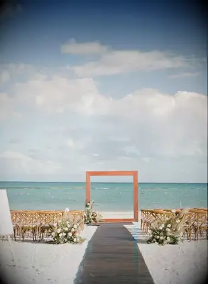 A modern geometric archway at a beachside wedding.
