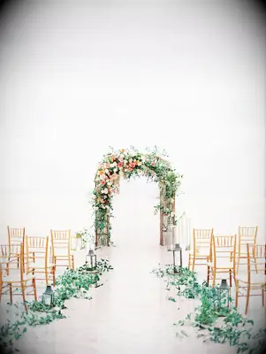 An asymmetrical wedding arch nestled among the beachside dunes.