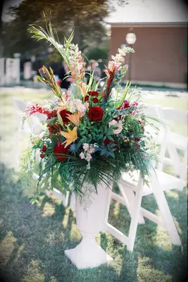 A vibrant floral arrangement with red roses and orange lilies. 