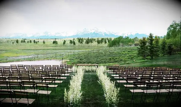 A ceremony site outdoors with a floral walkway down the aisle.