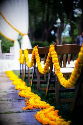 Vibrant yellow flower garlands lead guests to their seats.