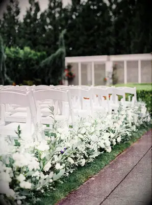 White flowers guide guests up the wedding aisle.