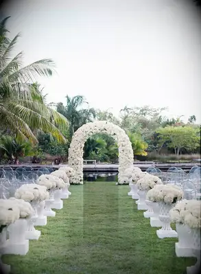White hydrangeas float, cloud-like, up this wedding aisle.