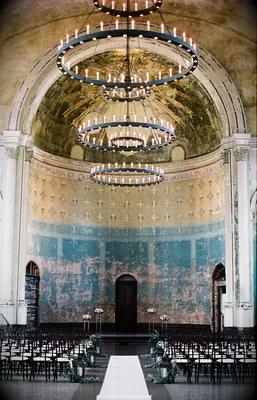A gorgeous antique chandelier hangs within this religious celebration space.