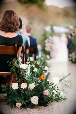 A gorgeous floral arrangement of white roses and vibrant greenery.