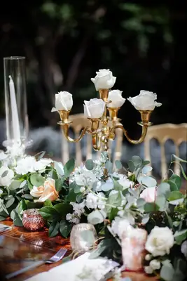 Roses Displayed in Gold Candleholder Among Eucalyptus