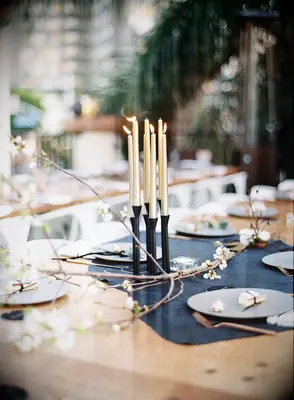 Gold taper candles in black candle holder