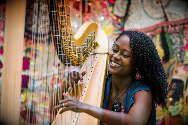 Musician playing the harp and smiling 