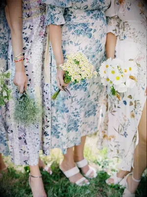 Bridesmaids hold different bouquets but with a similar color scheme.