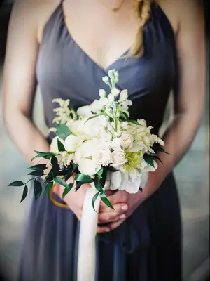 A bridesmaid holds this lovely pale bouquet.