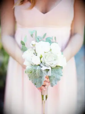 A bridesmaid holds this pale green and white bouquet.
