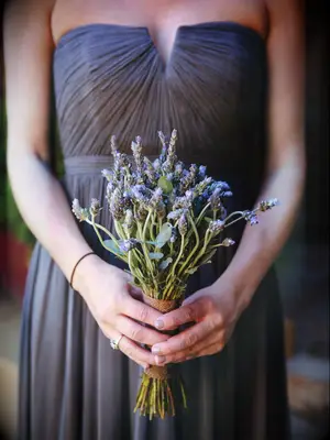 A bridesmaid holds a lavender bouquet.