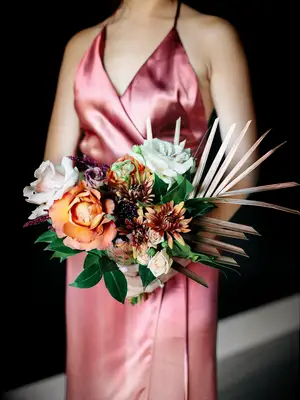 A bridesmaid holds this vibrant summertime bouquet.