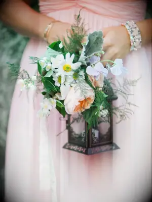 A bridesmaid holds this lantern bouquet.
