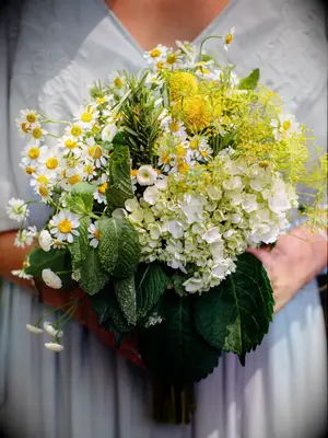 A bride holds this white and yellow bouquet.