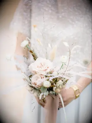 A bride holds this pale pink wildflower bouquet.