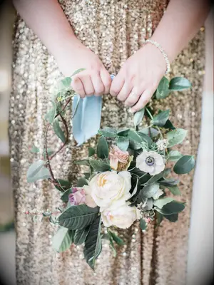 A bridesmaid holds a circular floral bouquet.