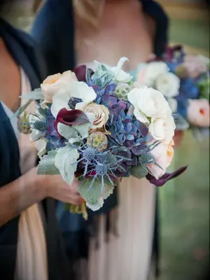 Bridesmaids hold wintery blue and white bouquets.