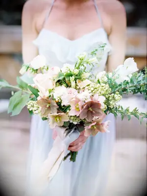 A bride holds this peach-toned bouquet.