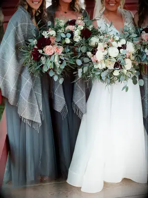 A bride and her wedding party hold vibrant winter bouquets.