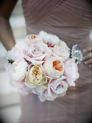 A bridesmaid holds this pale lavender and peach bouquet.