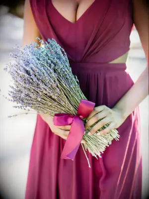 A bridesmaid holds a lavender bouquet.