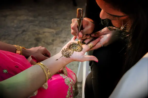 Bride having henna applied
