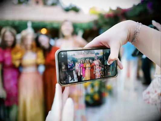 Person taking a photo of wedding guests on their phone