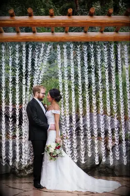 Couple posing in front of origami crane garlands