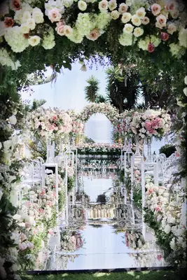 Tropical wedding flower arch with mirrored aisle