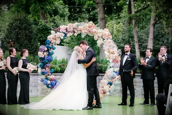 Couple kissing in front of colorful circle arch