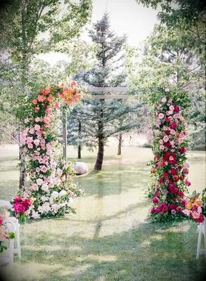 Wood arch covered in rainbow-hued fresh flowers