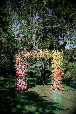 Floral arch covered in rainbow-hued fresh blooms