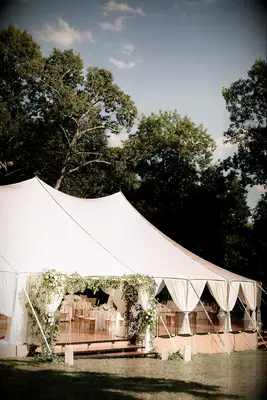 Sailcloth tent with greenery arch entryway