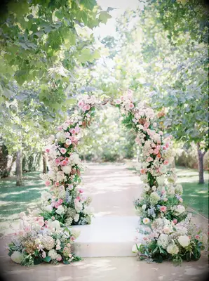 Garden arch covered in pink roses and white hydrangea