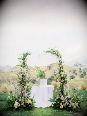 Ceremony altar with table and greenery arch with an opening at the top