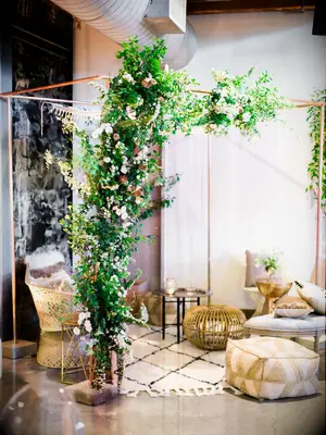 Boho lounge area under greenery-clad metal arch
