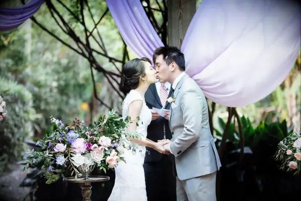 Couples first kiss holding hands at wedding