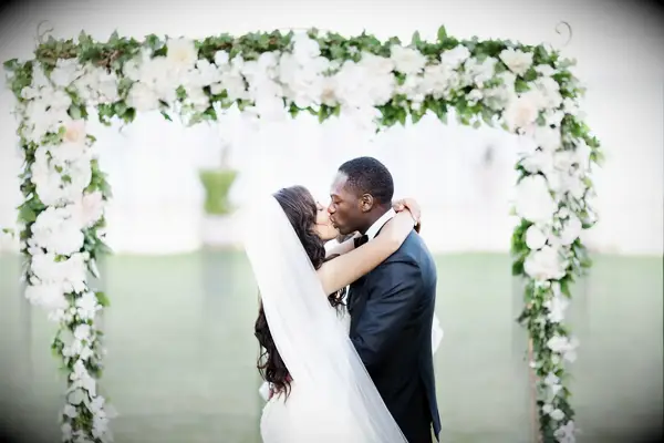 Couples first kiss with arms wrapped around