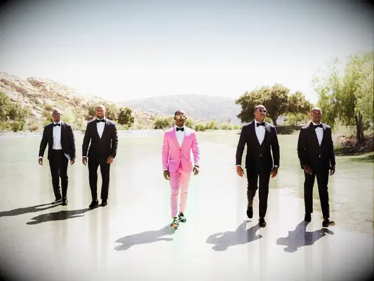 Groomsmen and groom walking into wedding reception