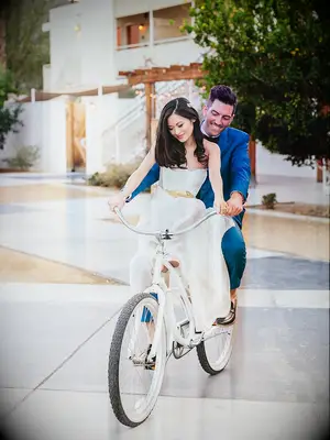A cute couple pose idea for wedding day photos, with a fun prop