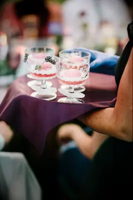 Server holding tray of sorbet mocktails at wedding