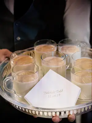 Server holding tray of eggnog mocktails at winter wedding