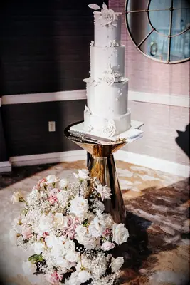 Multi-tiered white wedding cake with white florals