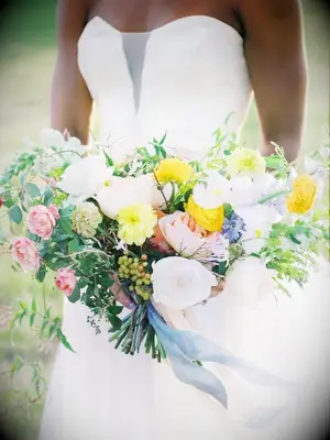 bride holding white-and-yellow wedding bouquet